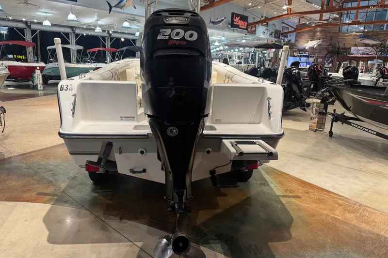 Slide: The Image of 2015 Mako 214 Center Console boat with 200 Pro Verado engine in showroom. - 9