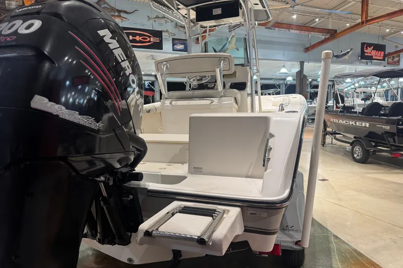 Slide: The Image of 2015 Mako 214 Center Console boat with Mercury engine in showroom. - 11