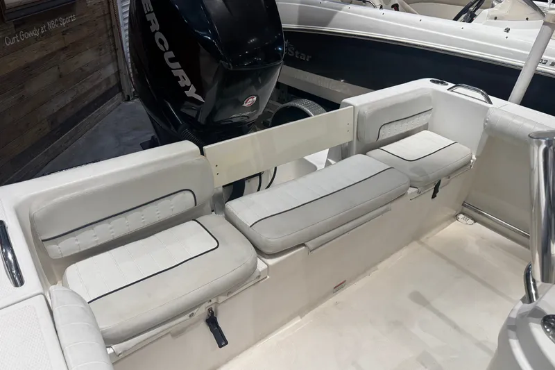 Slide: The Image of 2015 Mako 214 Center Console boat interior with cushioned seating and Mercury engine. - 8