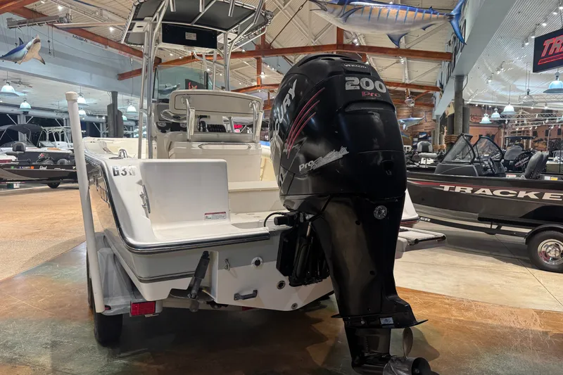 Slide: The Image of 2015 Mako 214 Center Console boat with Mercury 200 Pro outboard motor in showroom. - 12