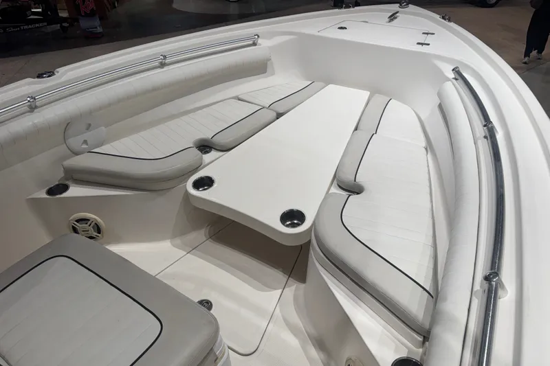 Slide: The Image of 2015 Mako 214 Center Console boat interior with cushioned seating and table. - 5
