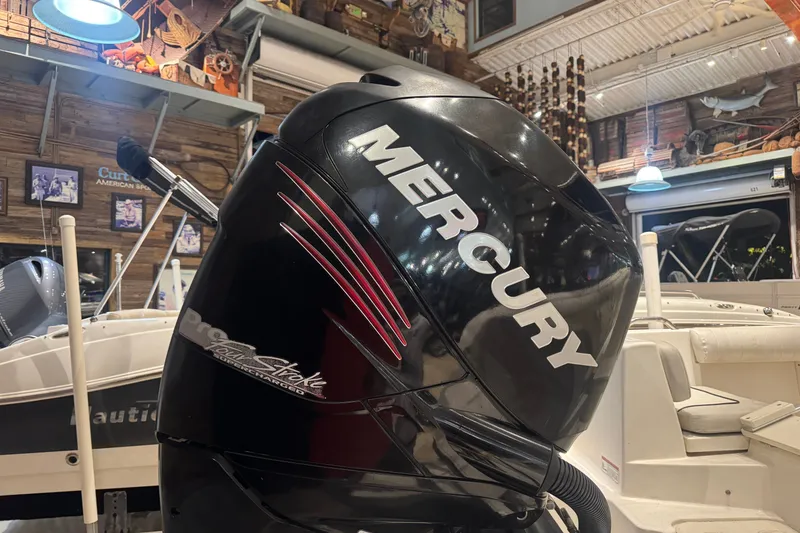 Slide: The Image of Mercury outboard motor on a 2015 Mako 214 Center Console boat in showroom. - 10