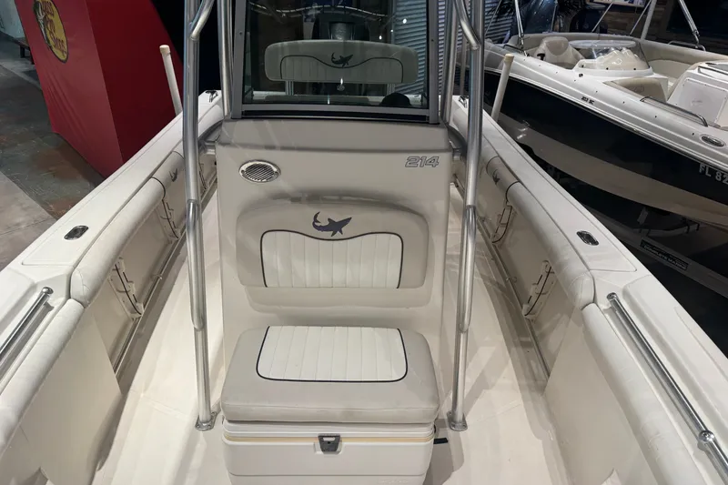 Slide: The Image of 2015 Mako 214 Center Console boat interior with cushioned seating and stainless steel railings. - 4