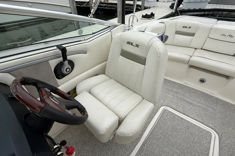 Slide: The Image of 2007 Sea Ray SLX 250 boat interior with white leather seating and wooden steering wheel. - 15