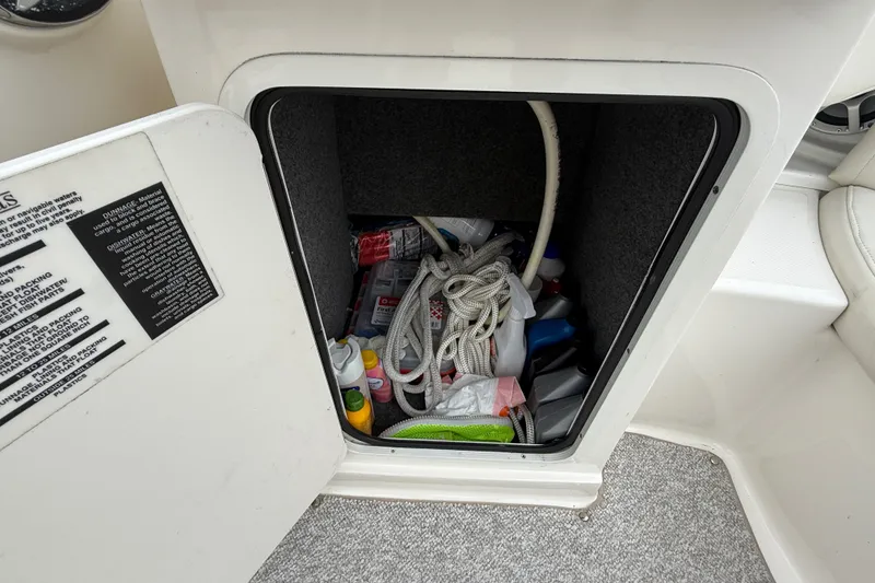 Slide: The Image of Storage compartment on a 2007 Sea Ray SLX 250 boat, filled with ropes and supplies. - 10