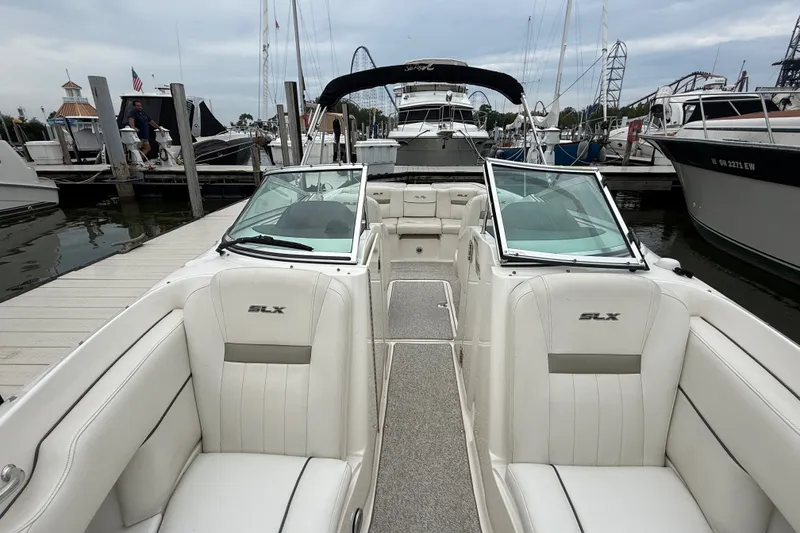 Slide: The Image of 2007 Sea Ray SLX 250 boat with white interior, docked at a marina. - 29