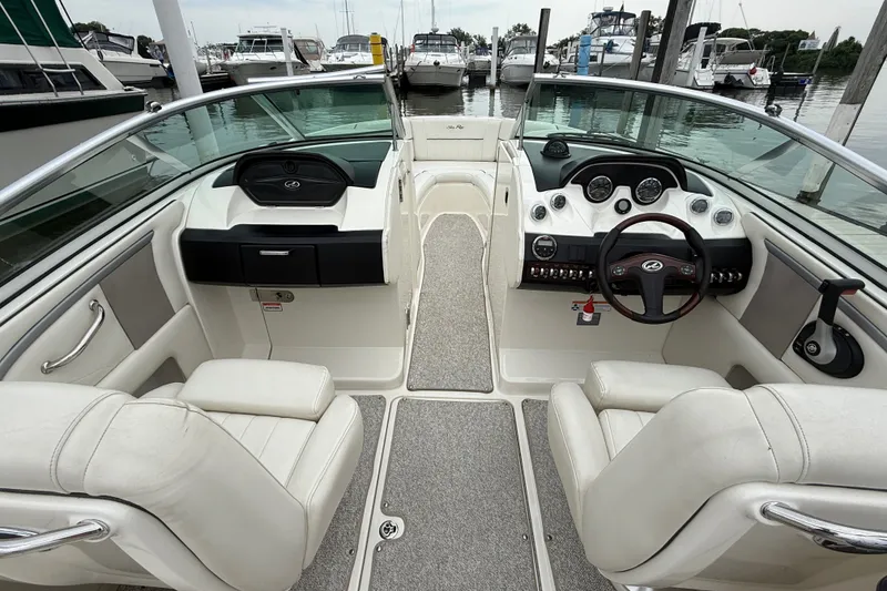 Slide: The Image of 2007 Sea Ray SLX 250 boat interior with dual seating and dashboard view at marina. - 11