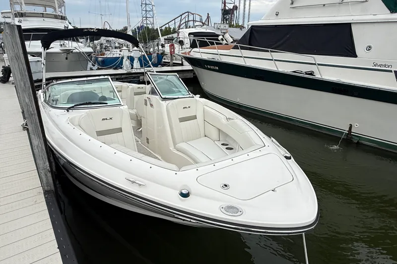 Slide: The Image of 2007 Sea Ray SLX 250 boat docked at marina, featuring sleek white design and spacious seating. - 6
