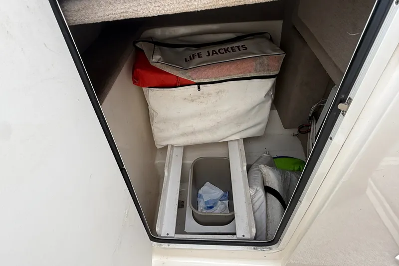 Slide: The Image of Storage compartment in a 2007 Sea Ray SLX 250 boat with life jackets and supplies. - 24