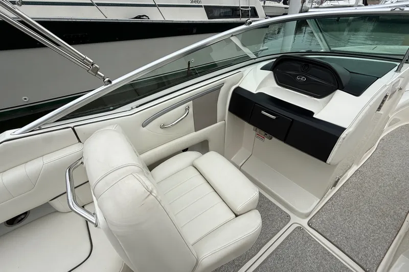 Slide: The Image of 2007 Sea Ray SLX 250 boat interior with white seating and sleek dashboard design. - 12