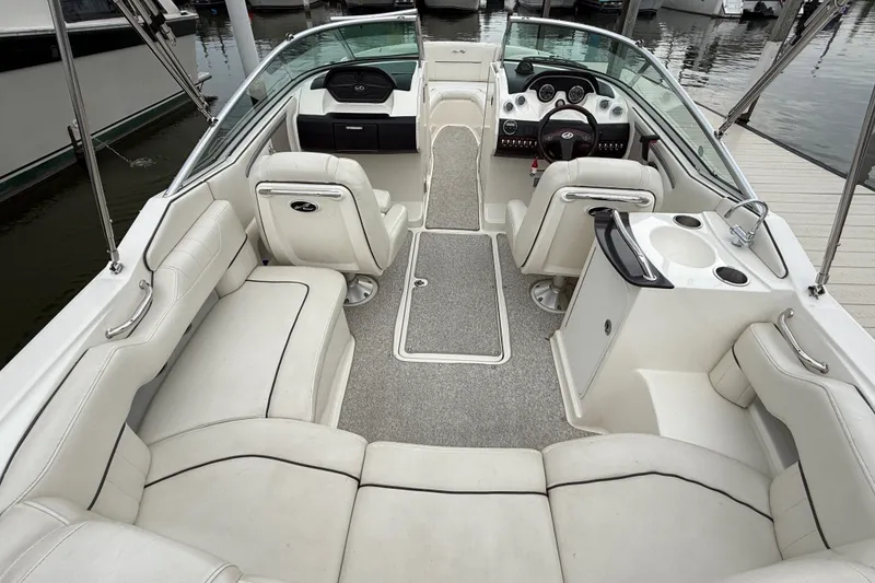 Slide: The Image of 2007 Sea Ray SLX 250 boat interior with white seating and helm, docked at marina. - 8