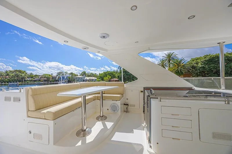 Slide: The Image of Luxurious 2010 Ocean Alexander 74 Motoryacht deck with seating and table, under clear blue sky. - 18