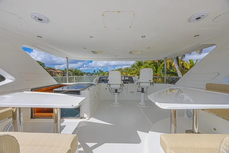 Slide: The Image of Luxurious 2010 Ocean Alexander 74 Motoryacht flybridge with seating and helm, surrounded by tropical scenery. - 12