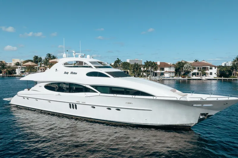 The Image of Luxurious 2004 Lazzara 106 yacht cruising on a sunny day near waterfront homes. - 0