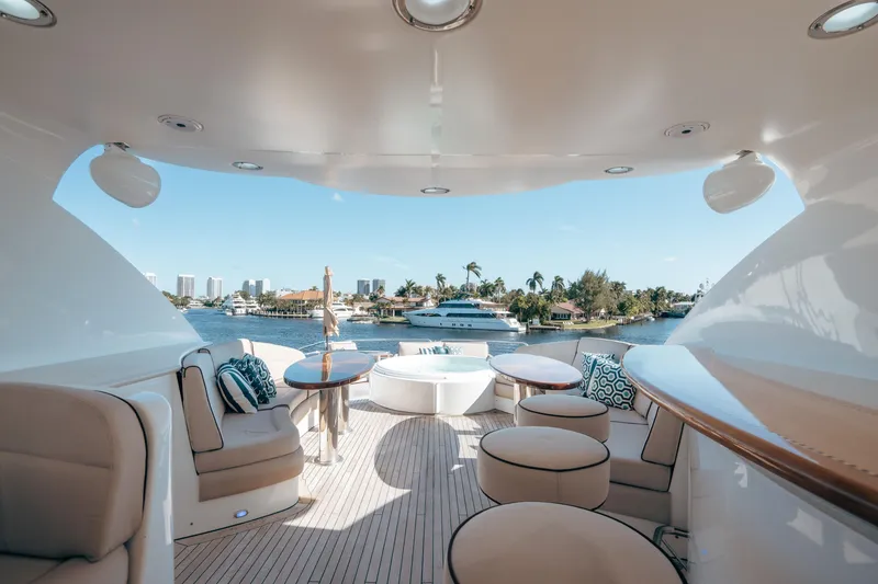 Slide: The Image of Luxurious 2004 Lazzara 106 yacht deck with elegant seating and scenic waterfront view. - 13