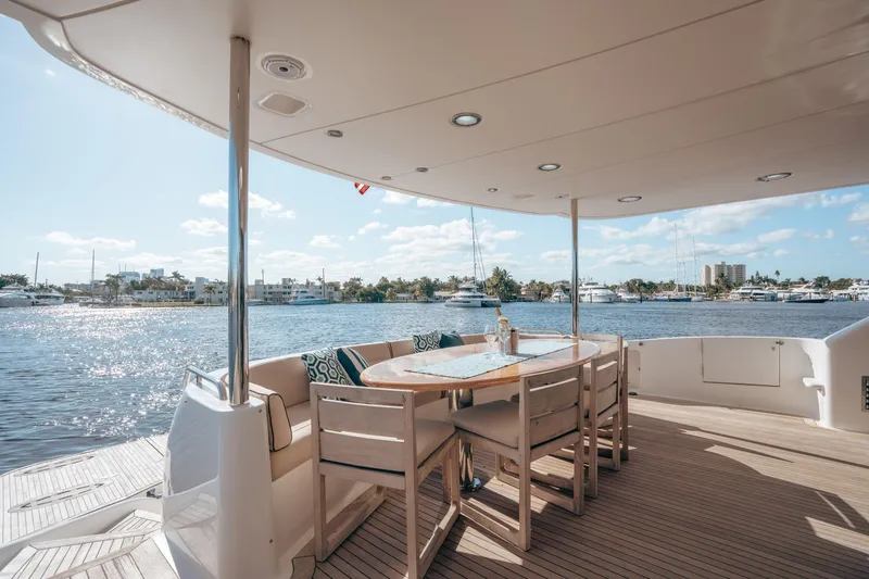 Slide: The Image of Luxurious 2004 Lazzara 106 yacht deck with elegant dining area overlooking serene waters. - 26