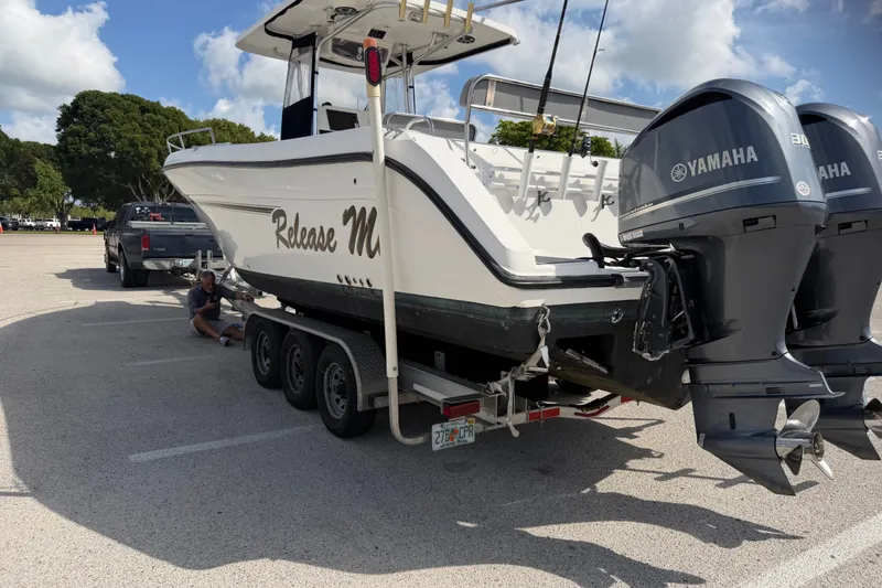 Slide: The Image of 2006 Century 3200 Center Console boat on trailer with Yamaha engines in parking lot. - 7