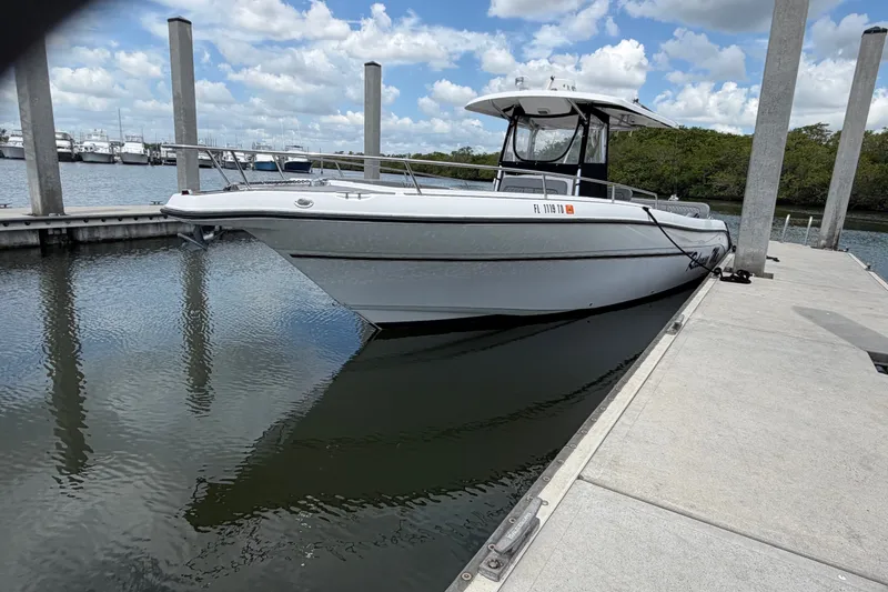 Slide: The Image of 2006 Century 3200 Center Console boat docked at marina under blue sky. - 2