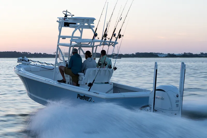 Slide: The Image of Manufacturer Provided Image: 2027 Parker 240 Coastal Elite boat cruising at sunset with fishing rods. - 1