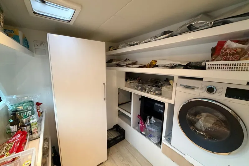 Slide: The Image of Laundry and storage area inside 2023 Longreach 58 Expedition yacht, featuring shelves and a washing machine. - 68