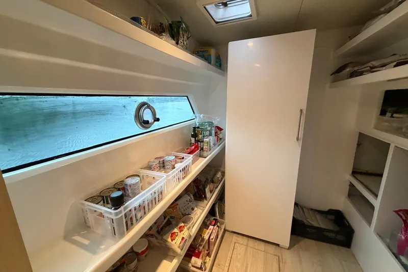 Slide: The Image of Pantry storage inside 2023 Longreach 58 Expedition yacht, featuring shelves with canned goods and supplies. - 69