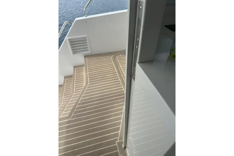 Slide: The Image of Deck view of 2023 Longreach 58 yacht with sleek, modern design and water backdrop. - 17