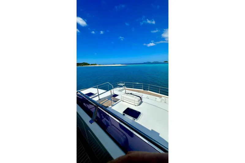 Slide: The Image of Longreach 58 yacht deck with ocean view, 2023 model, under clear blue sky. - 9