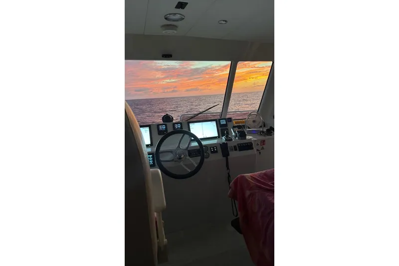 Slide: The Image of Cockpit view of 2023 Longreach 58 yacht at sunset over the ocean. - 14
