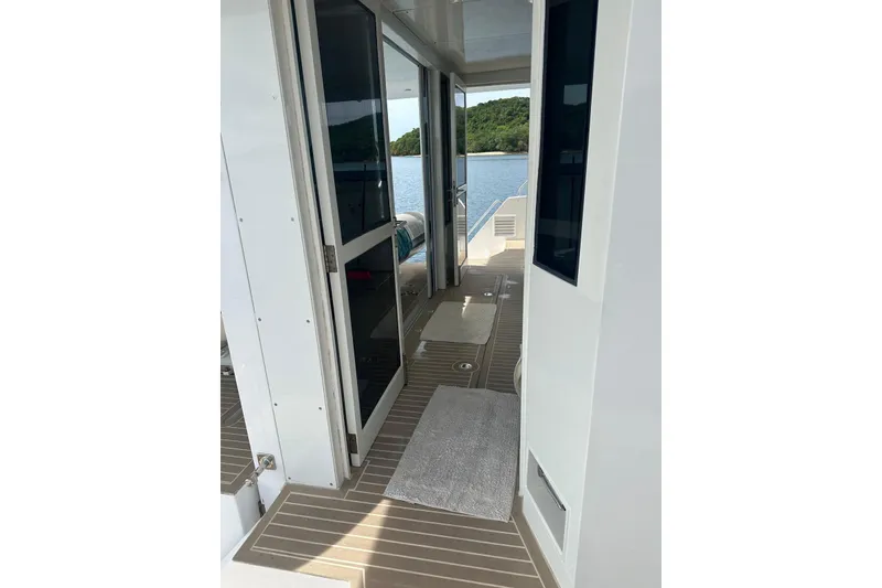 Slide: The Image of Modern Longreach 58 yacht interior with sleek design, open doors, and scenic water view, 2023 model. - 16