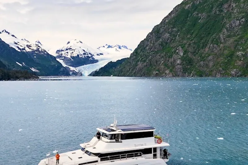 Slide: The Image of Longreach 58 yacht cruising in scenic glacier fjord, surrounded by snow-capped mountains, 2023. - 2
