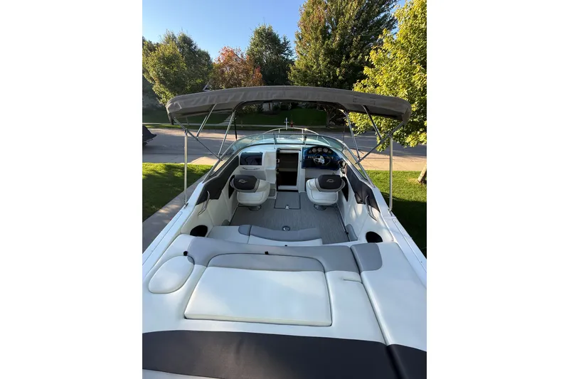 Slide: The Image of 2017 Rinker QX23 CC boat with canopy, spacious seating, and modern dashboard. - 17