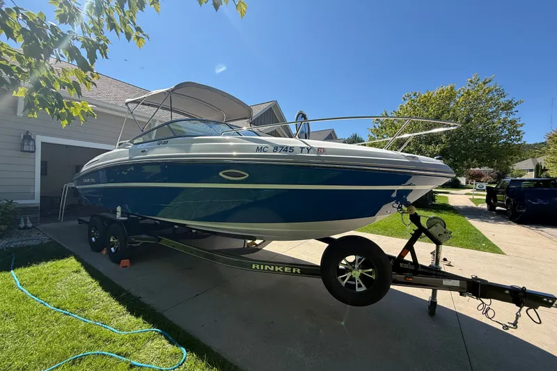 Slide: The Image of 2017 Rinker QX23 CC boat on trailer in suburban driveway, sunny day. - 10