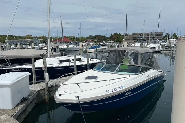 Slide: The Image of 2017 Rinker QX23 CC boat docked in a marina with other vessels. - 1
