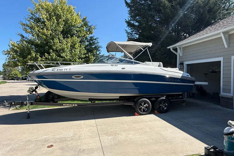 Slide: The Image of 2017 Rinker QX23 CC boat on trailer in driveway, sunny day. - 11