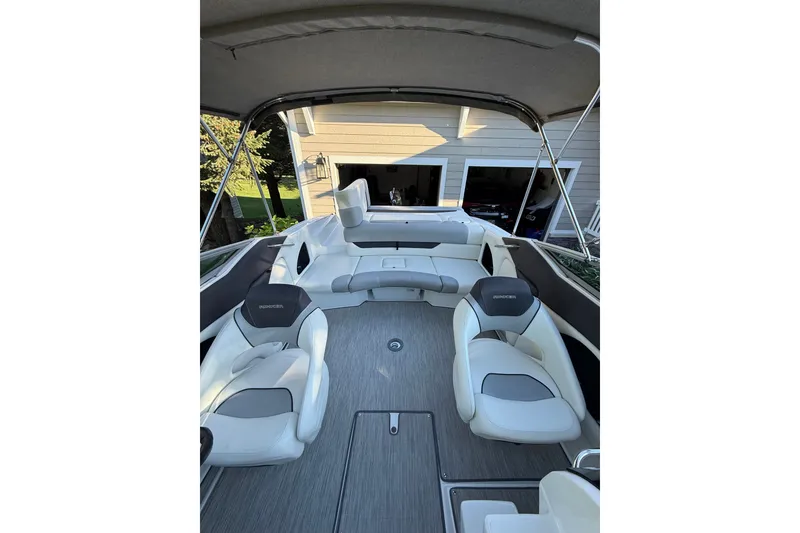 Slide: The Image of 2017 Rinker QX23 CC boat interior with white seating and canopy. - 15