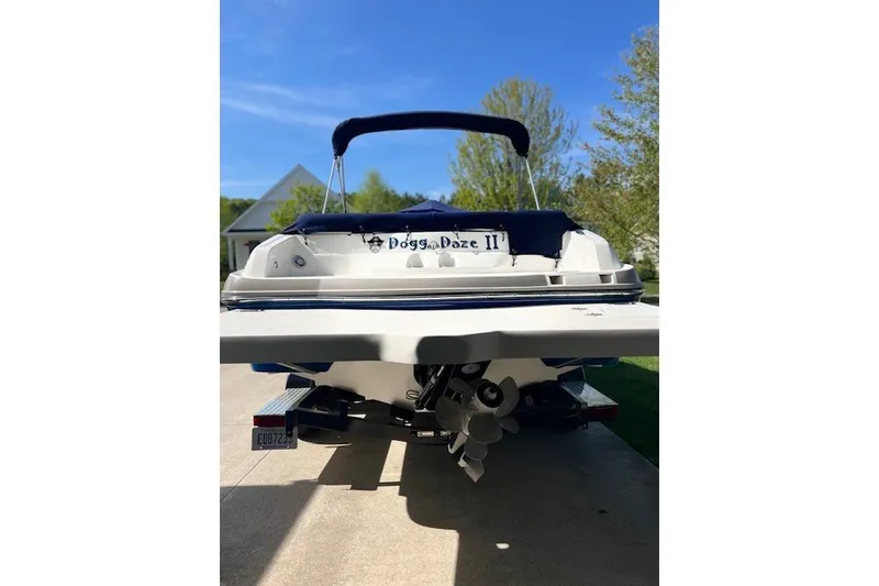 Slide: The Image of 2017 Rinker QX23 CC boat on trailer, rear view with canopy, parked outdoors. - 12