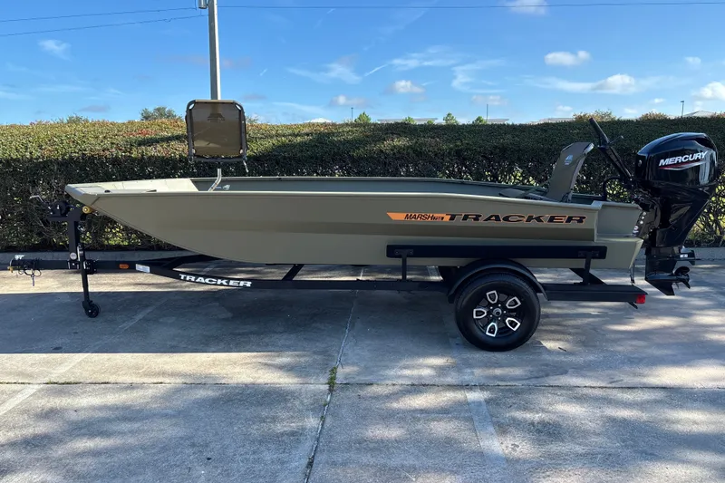 The Image of 2027 Tracker Grizzly 1756 T Marsh boat on trailer, featuring Mercury outboard motor. - 0