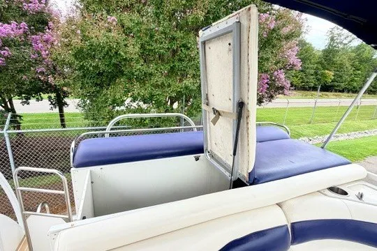 Slide: The Image of 2006 JC 23 Neptoon TT boat interior with open storage compartment and blue seating. - 20