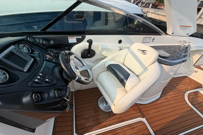 Slide: The Image of 2013 Monterey 264FSX boat interior with steering wheel, dashboard, and captain's seat. - 14