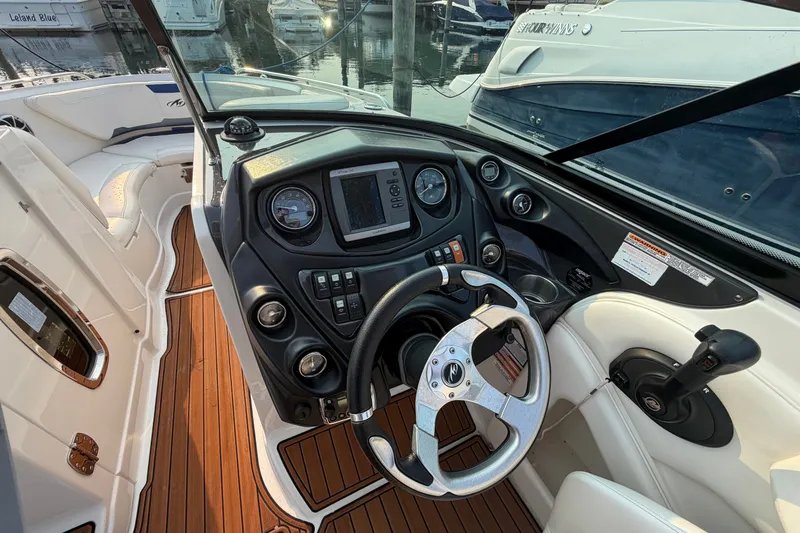 Slide: The Image of 2013 Monterey 264FSX boat cockpit with modern controls and wooden flooring. - 11