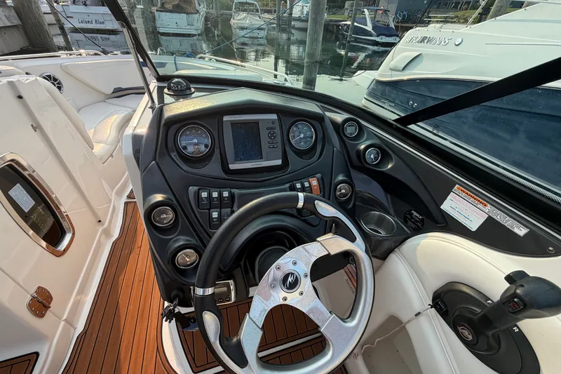 Slide: The Image of Cockpit view of a 2013 Monterey 264FSX boat with steering wheel and control panel. - 13