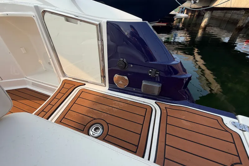 Slide: The Image of 2013 Monterey 264FSX boat deck with wood finish, docked by the water. - 3