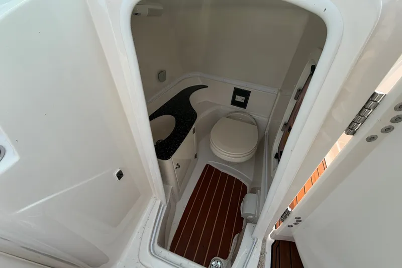 Slide: The Image of 2013 Monterey 264FSX boat bathroom with toilet and wooden flooring. - 17