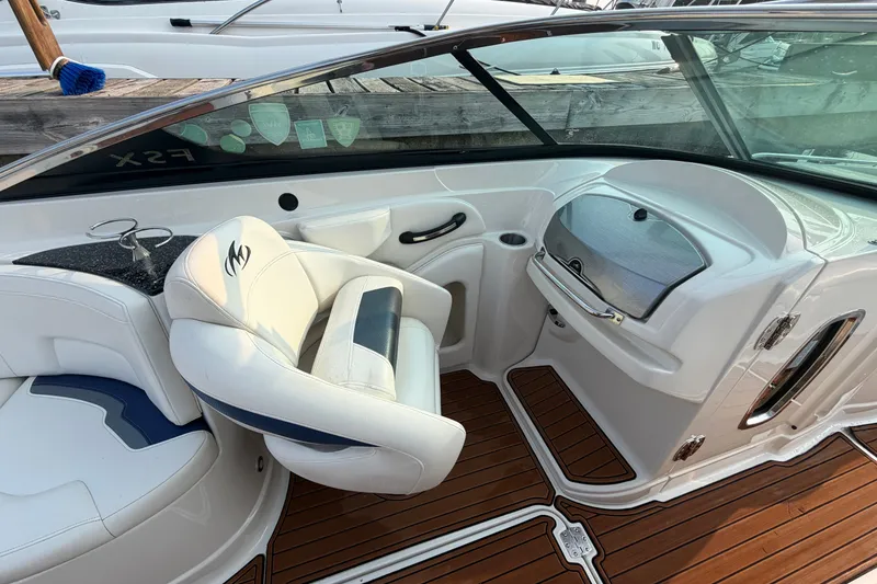 Slide: The Image of Interior of a 2013 Monterey 264FSX boat with white seating and wood flooring. - 15