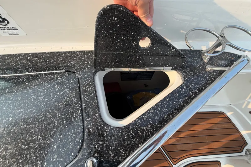 Slide: The Image of 2013 Monterey 264FSX boat with open storage compartment and speckled countertop. - 9