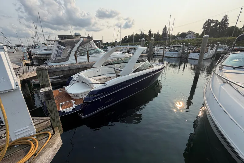The Image of 2013 Monterey 264FSX boat docked in a marina, surrounded by other vessels. - 0