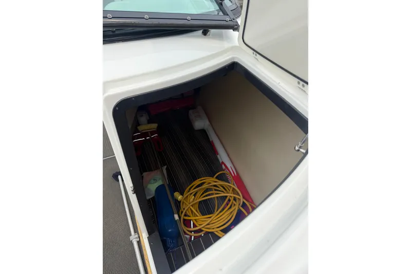 Slide: The Image of Open storage compartment in 2016 Monterey 328SS Super Sport boat, containing various boating accessories. - 7