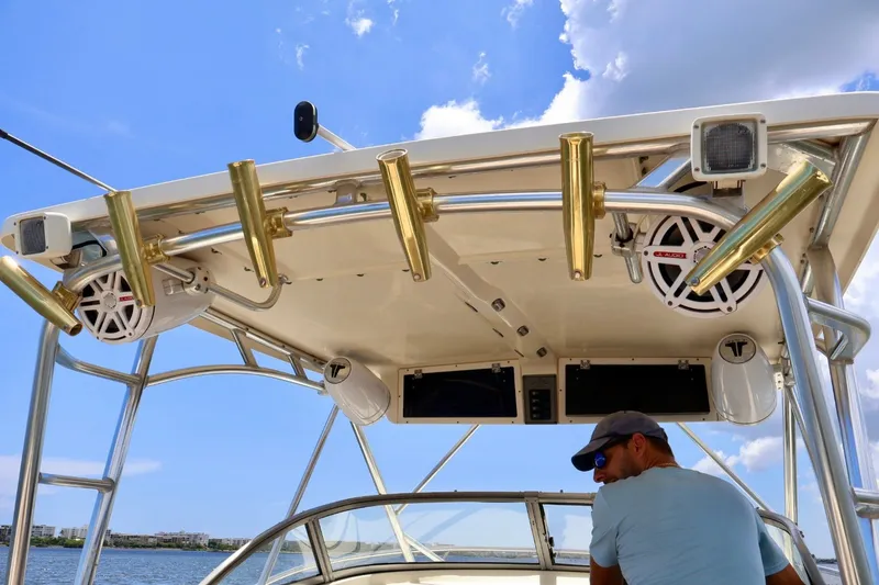 Slide: The Image of Man on 2003 Scout 280 Abaco boat with rod holders and speakers under clear sky. - 9