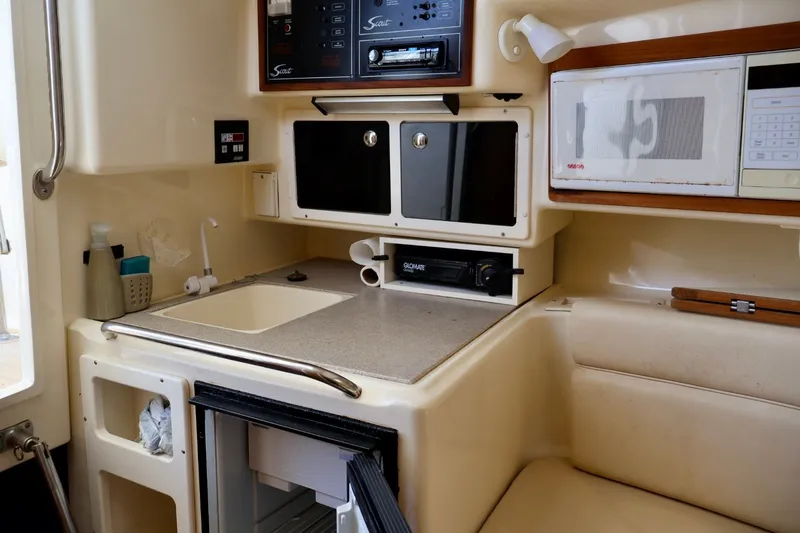 Slide: The Image of Compact kitchen area in a 2003 Scout 280 Abaco boat with sink, microwave, and storage. - 15