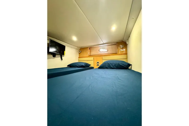 Slide: The Image of 2009 Four Winns V458 cabin interior with bed, TV, and wooden accents. - 35